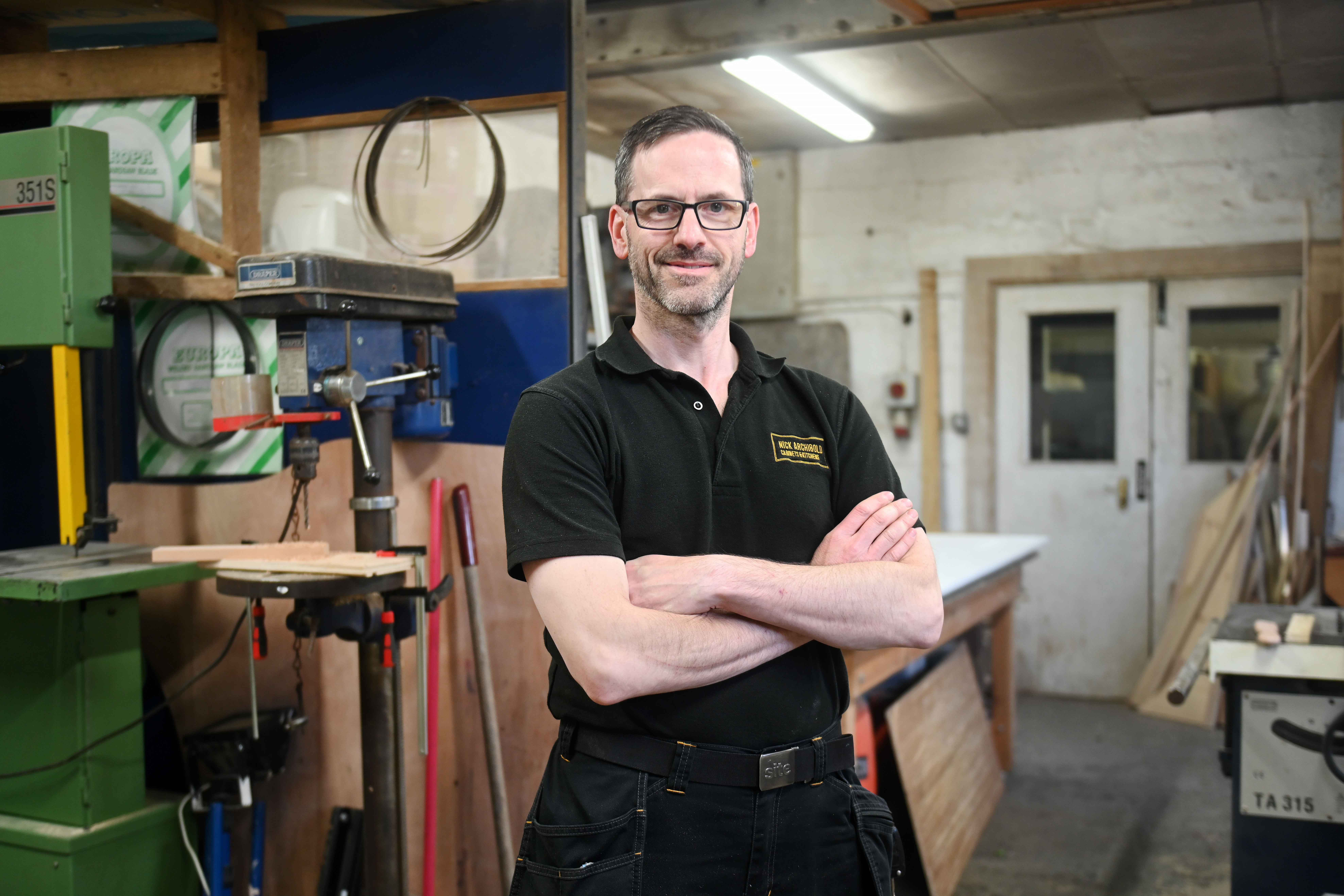 Nick standing beside the machinery in his Corsham workshop.