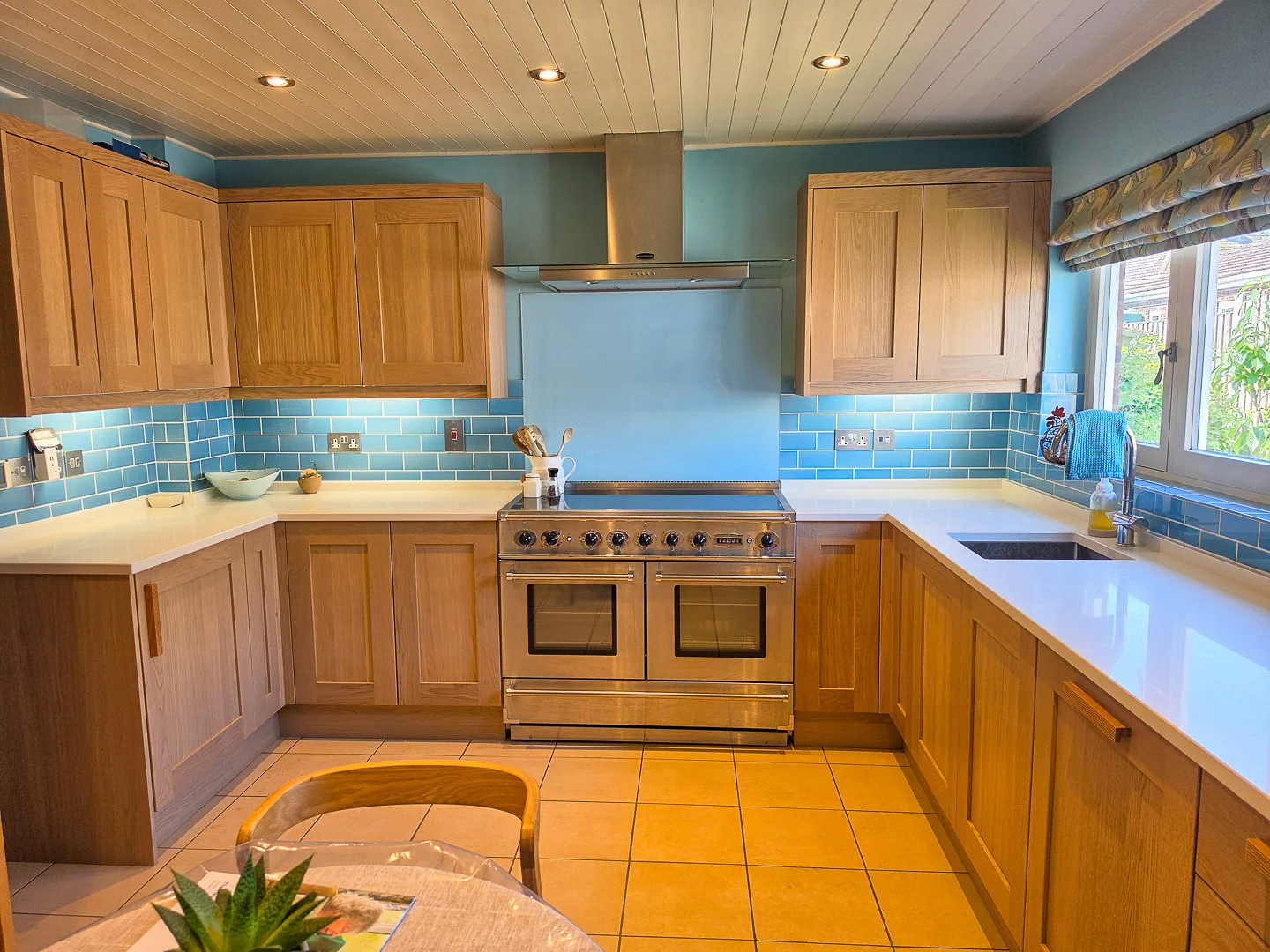 Refreshed oak shaker kitchen in Wiltshire with white worktops, blue metro tiles and a range cooker
