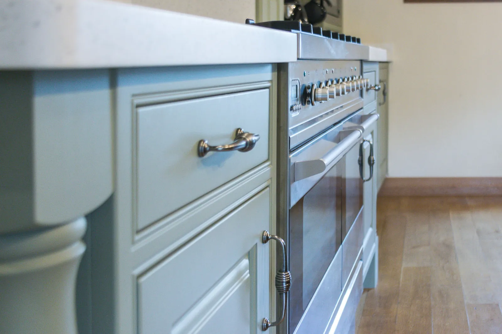 Sprayed drawer fronts in sage green either side of a stainless steel range cooker, in Bradford on Avon