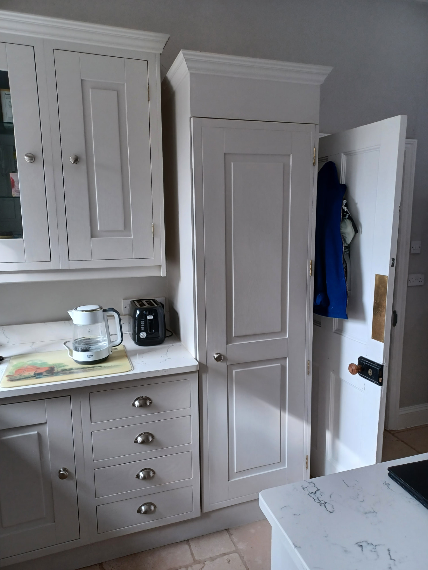 Existing Malmesbury kitchen cabinetry before the refresh, with differing cupboard heights and upper mouldings