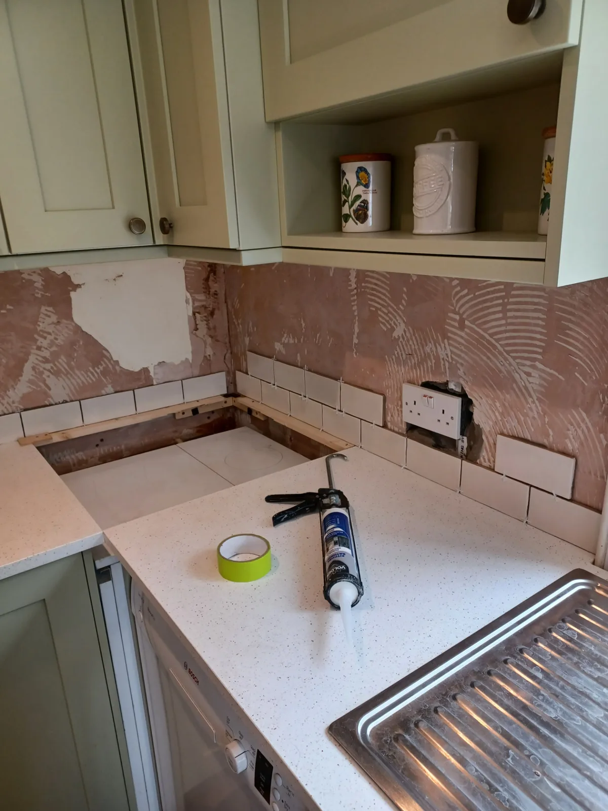 Kitchen part-way through a refresh in Wiltshire with new stone worktop fitted and a tiled splashback being set out