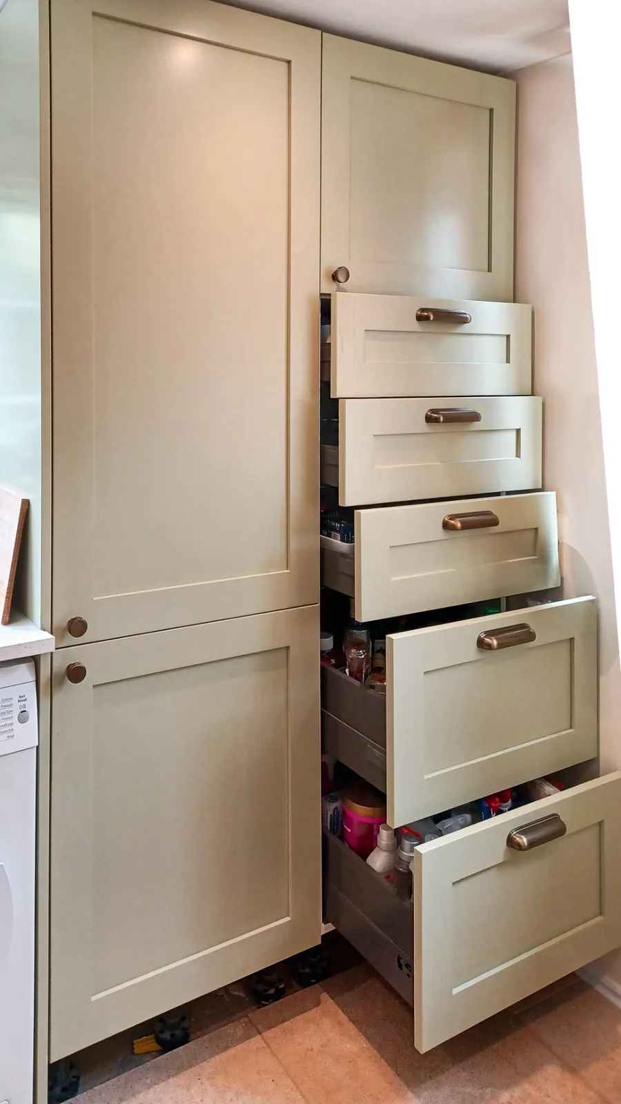 Tall larder cabinet with deep pull-out drawers for cooking ingredients in a Wiltshire kitchen