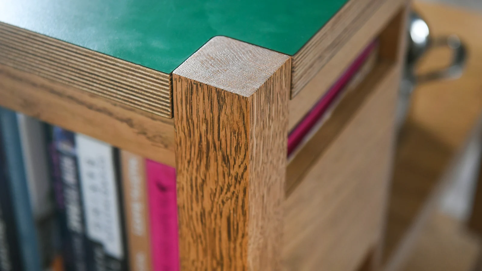 Solid oak corner post rising up through the green worktop in the Melksham bespoke kitchen