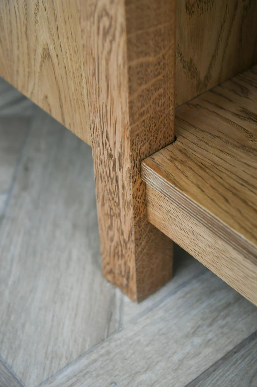 Close-up of a solid oak leg and lower shelf in the Melksham bespoke kitchen, with the exposed layered edge of the plywood shelf