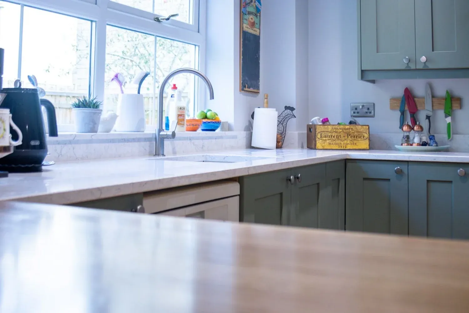 Quartz worktop and green cabinetry in the cooking zone