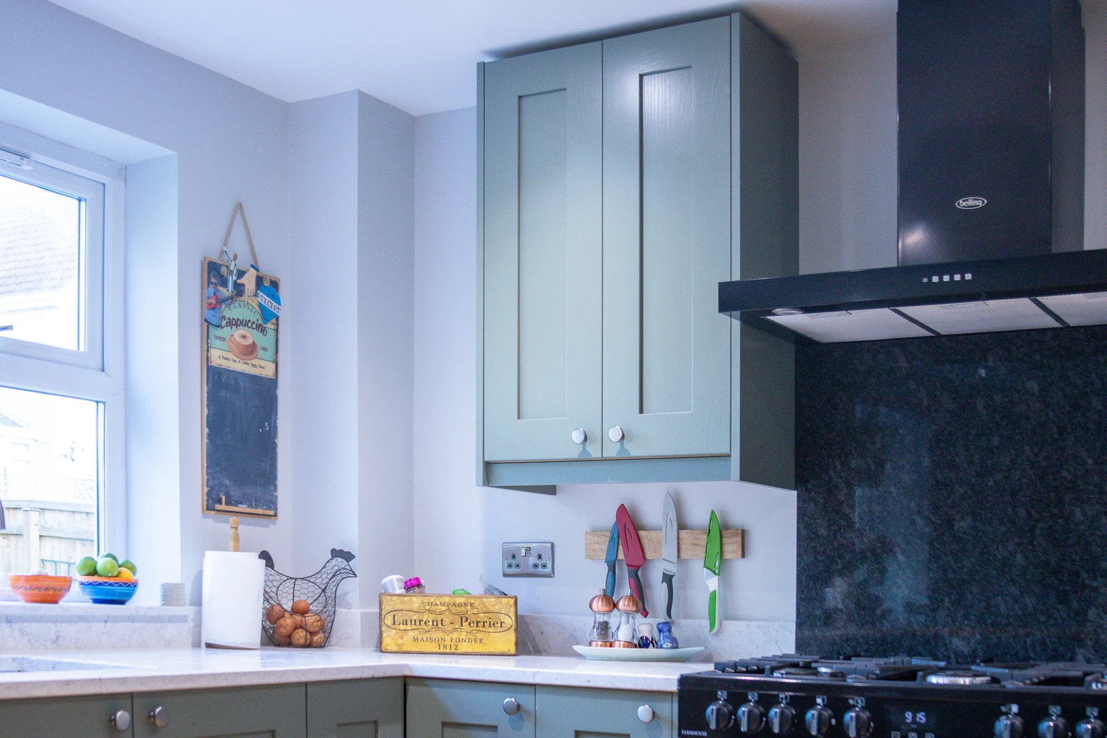 Tall Regiment Green shaker wall unit beside the extractor hood above the range cooker in the Corsham custom kitchen