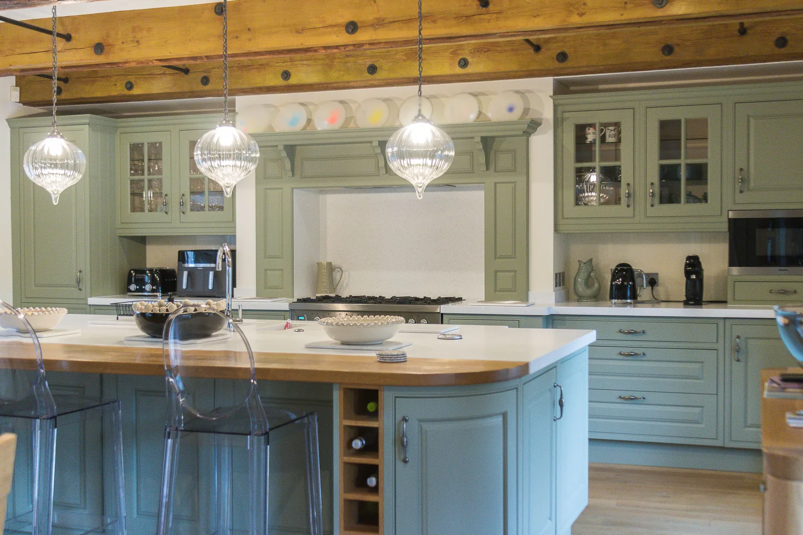 A newly resprayed kitchen cabinet door in a modern soft green finish, showing smooth, even paintwork.
