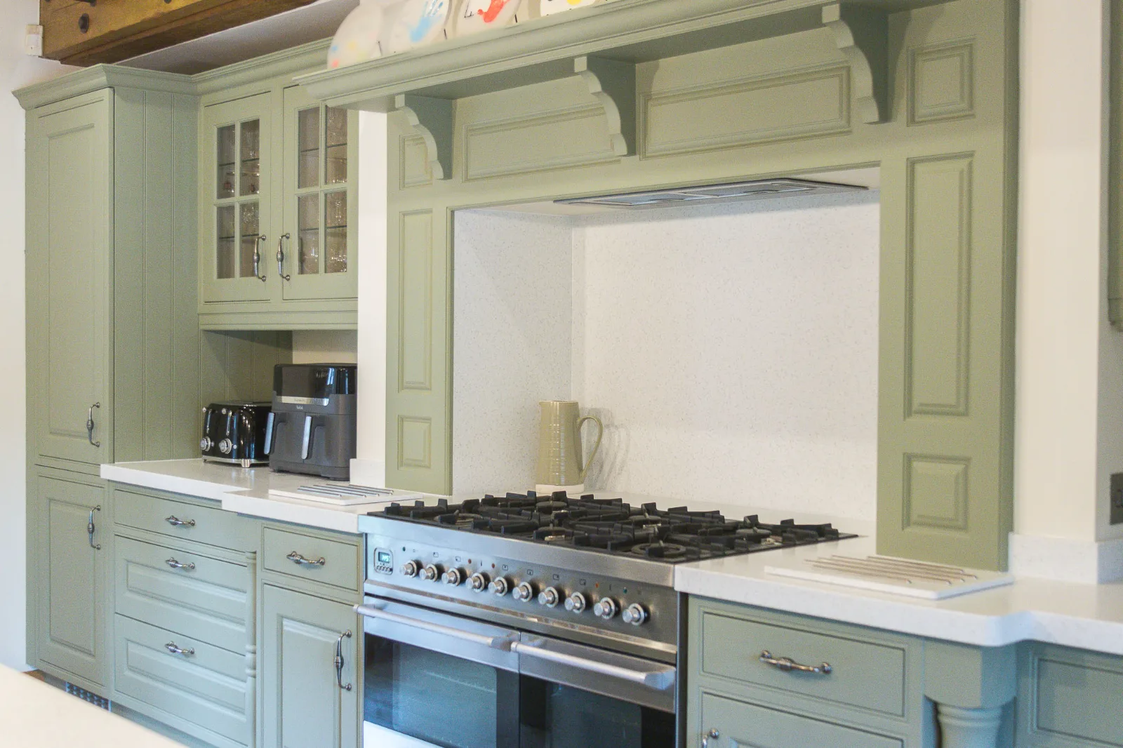 The finished Bradford-on-Avon kitchen with cabinetry sprayed in Farrow & Ball Lichen and the range cooker and other appliances retained.