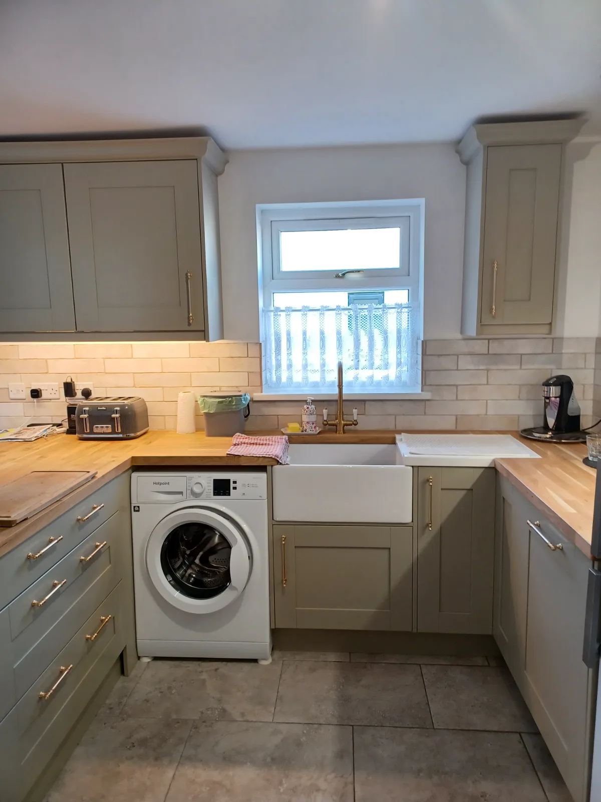 A newly installed solid oak kitchen worktop, showing natural grain and a clean finish next to a ceramic sink, reflecting quality craftsmanship.