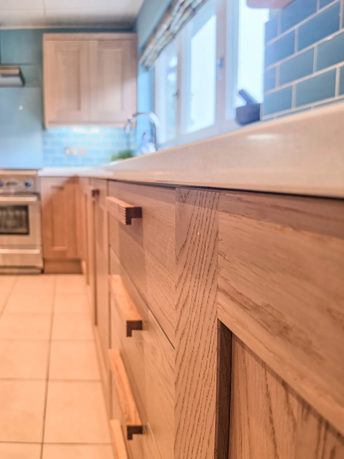 Close detail of solid oak drawer fronts and quartz worktop edge