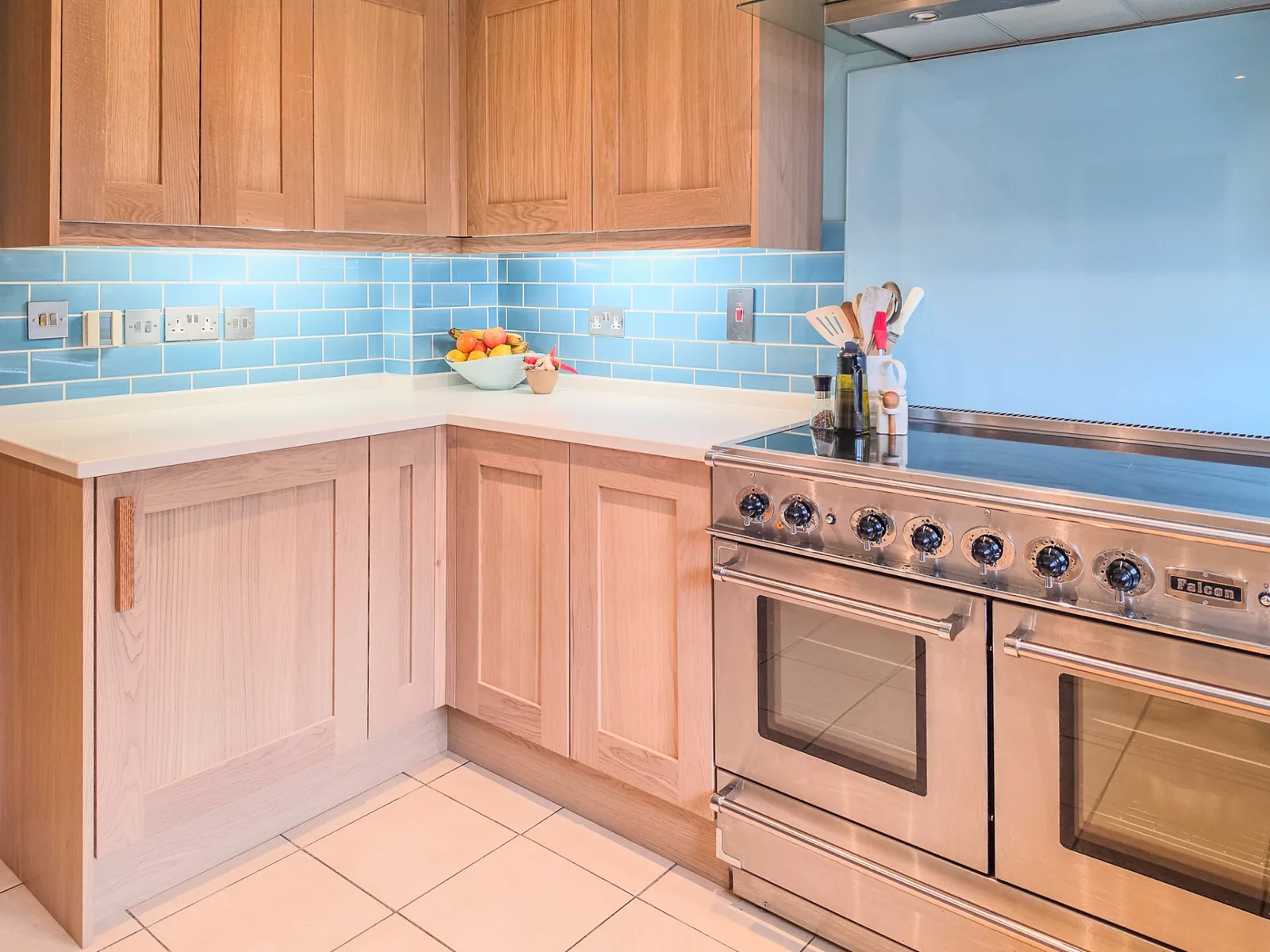 Solid oak cabinet doors and quartz worktops beside the range cooker