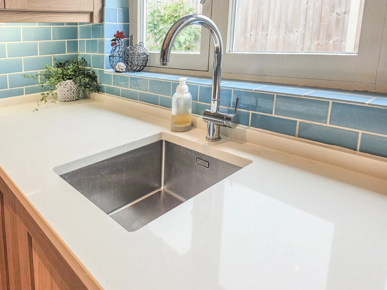 New metal undermount sink and mixer tap in pale quartz worktop