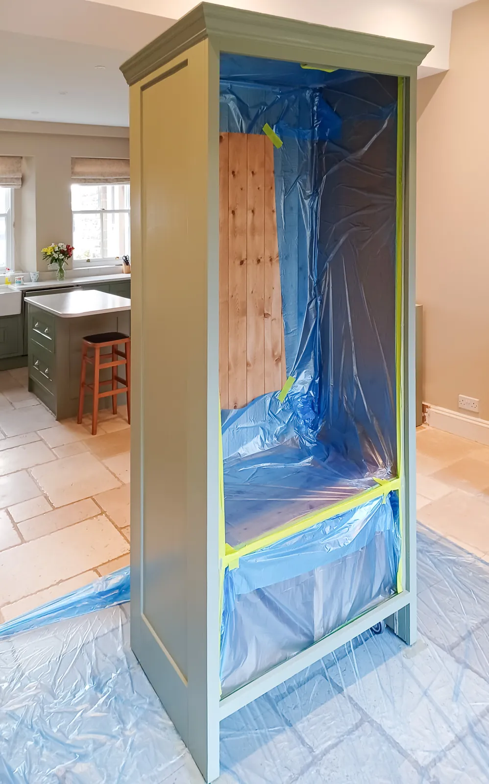 The tall grey larder cupboard being hand painted