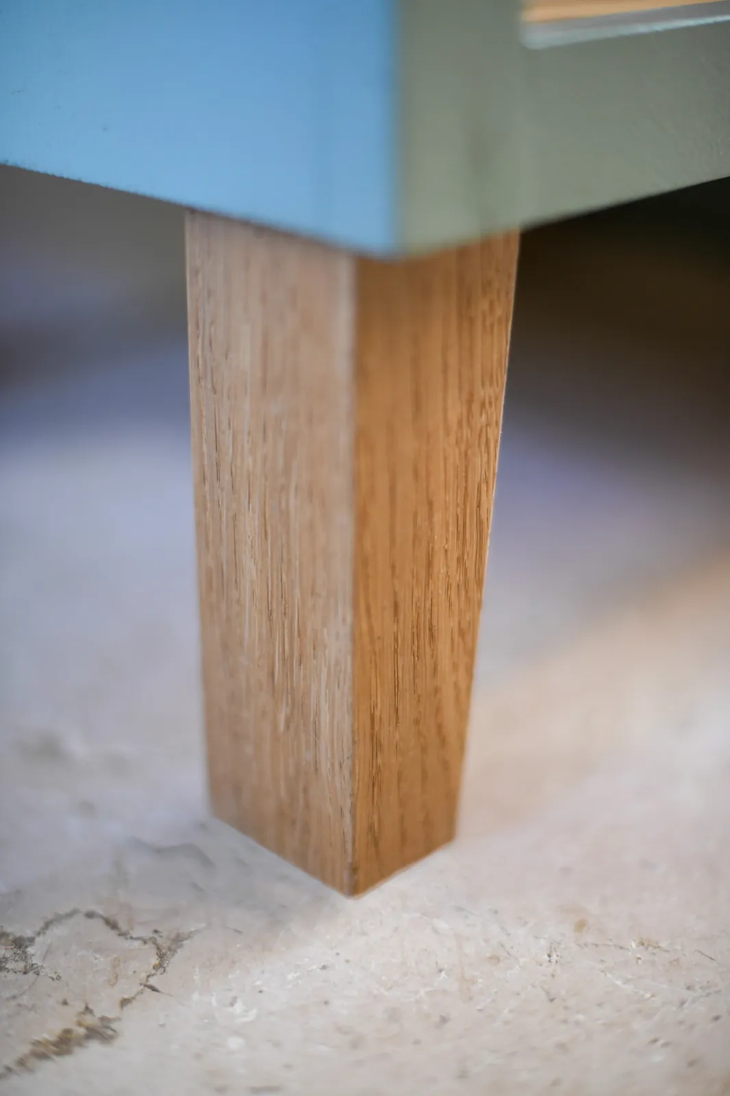 A solid oak foot beneath the bespoke bookcase