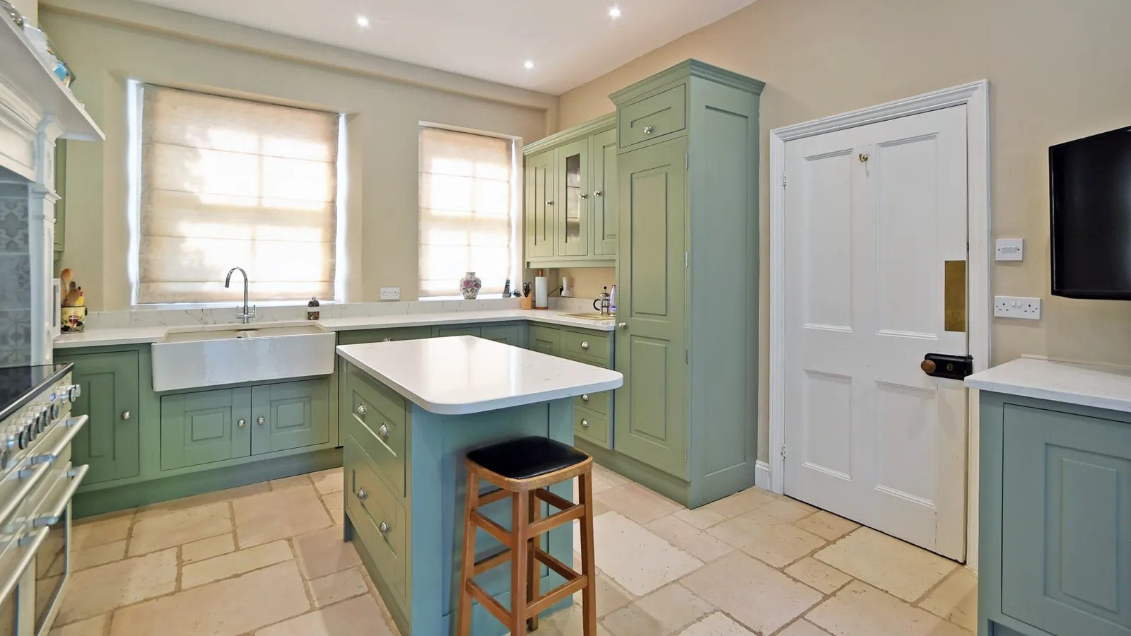 The sink run and island in the resprayed green kitchen