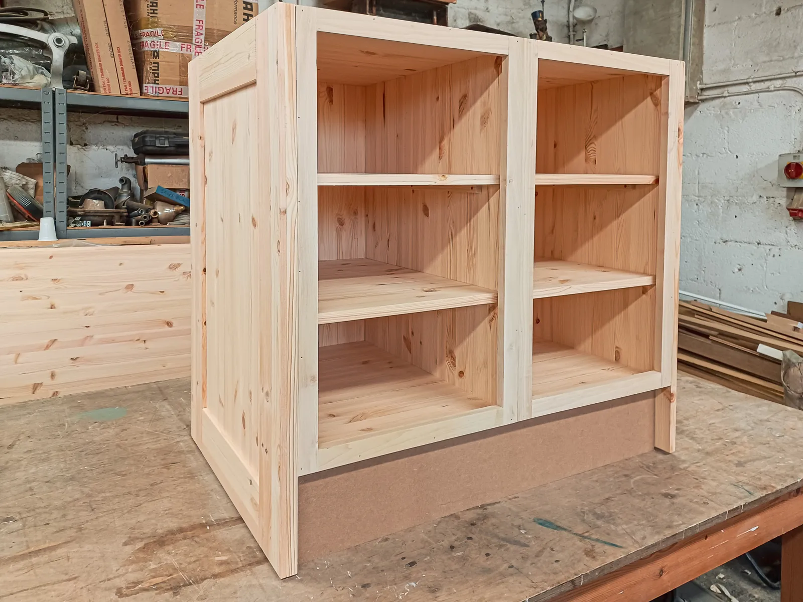 A solid pine bespoke base cabinet carcase on the workshop bench